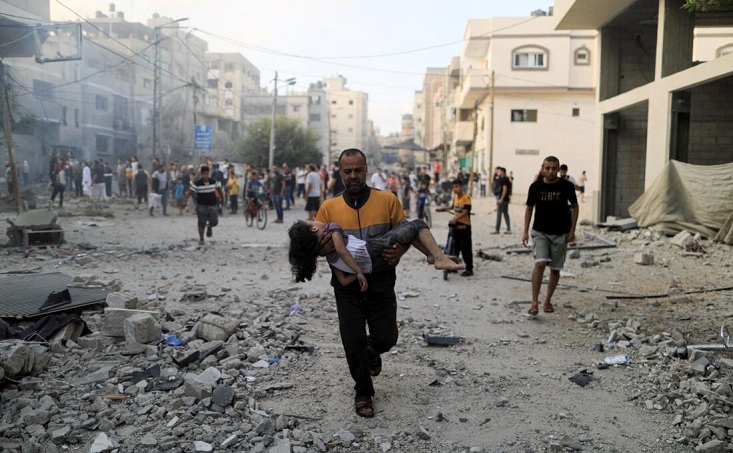 Palestino carrega criança no colo após ataque de Israel na Faixa de Gaza - Foto: Yasser Qudih / AFP 