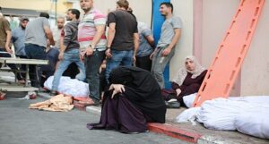 Mulher palestina chora diante de hospital. Apenas 13 dos 36 estão funcionando. E mesmo assim parcialmente